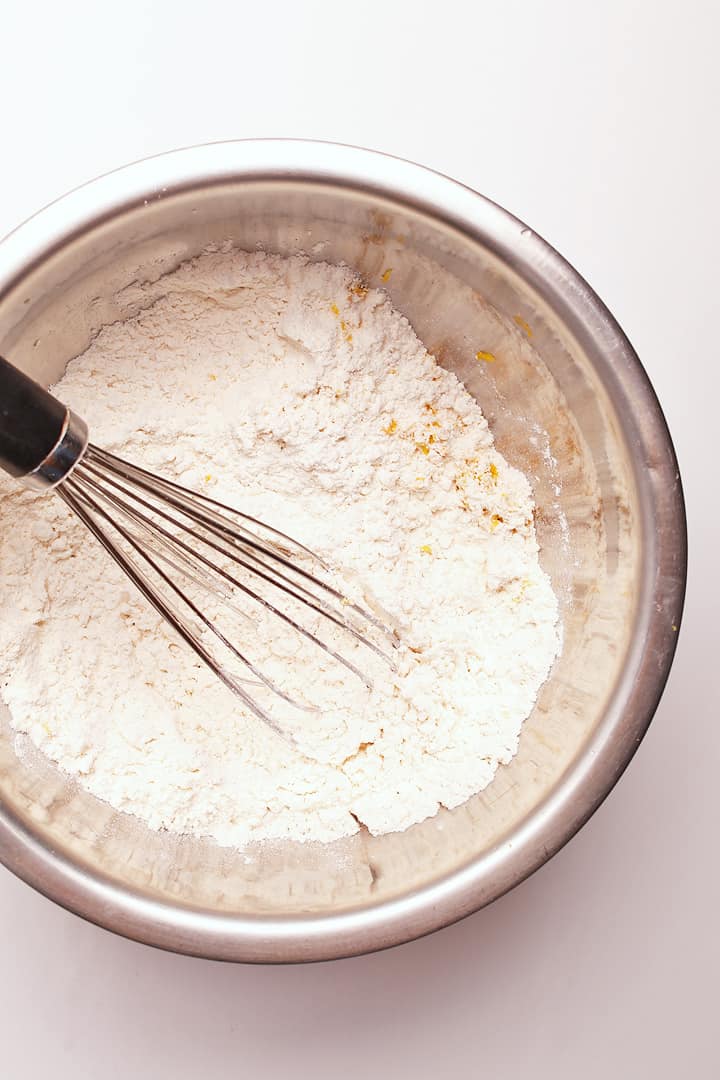 Flour and spices in a metal bowl with a whisk