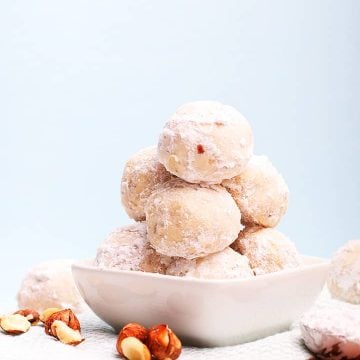 Stack of snowball cookies in a small white bowl