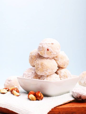 Stack of snowball cookies in a small white bowl