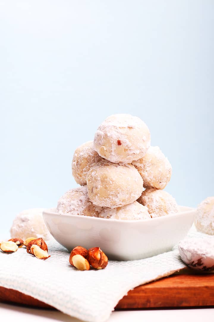 Stack of snowball cookies in a small white bowl