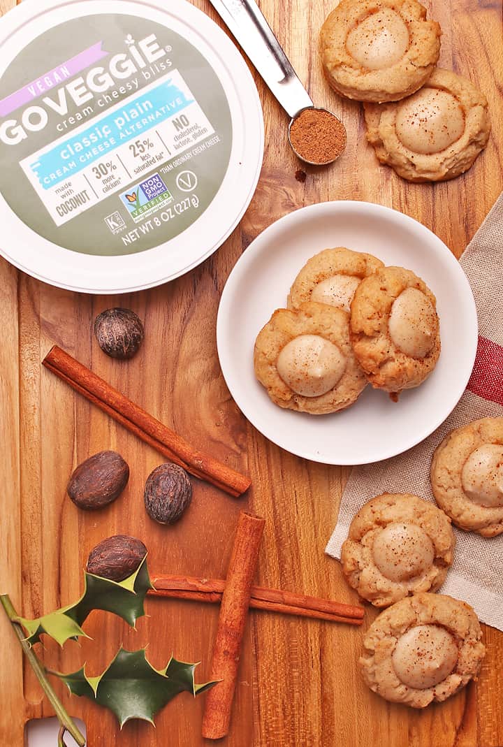 Eggnog Thumbprint Cookies on wooden platter with spices