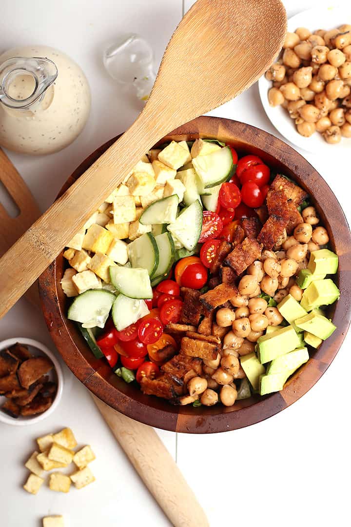 Vegan Cobb Salad in a wooden bowl with salad tongs