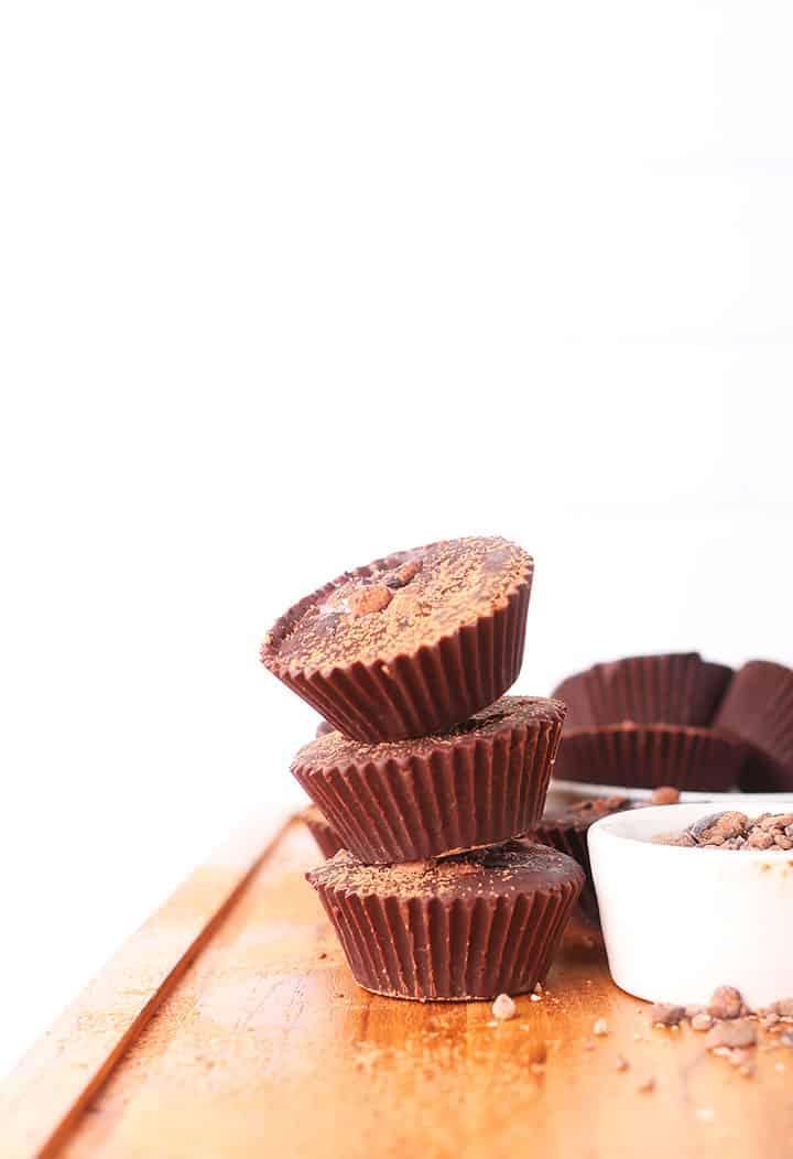 Stack of raw chocolate cups on wooden board