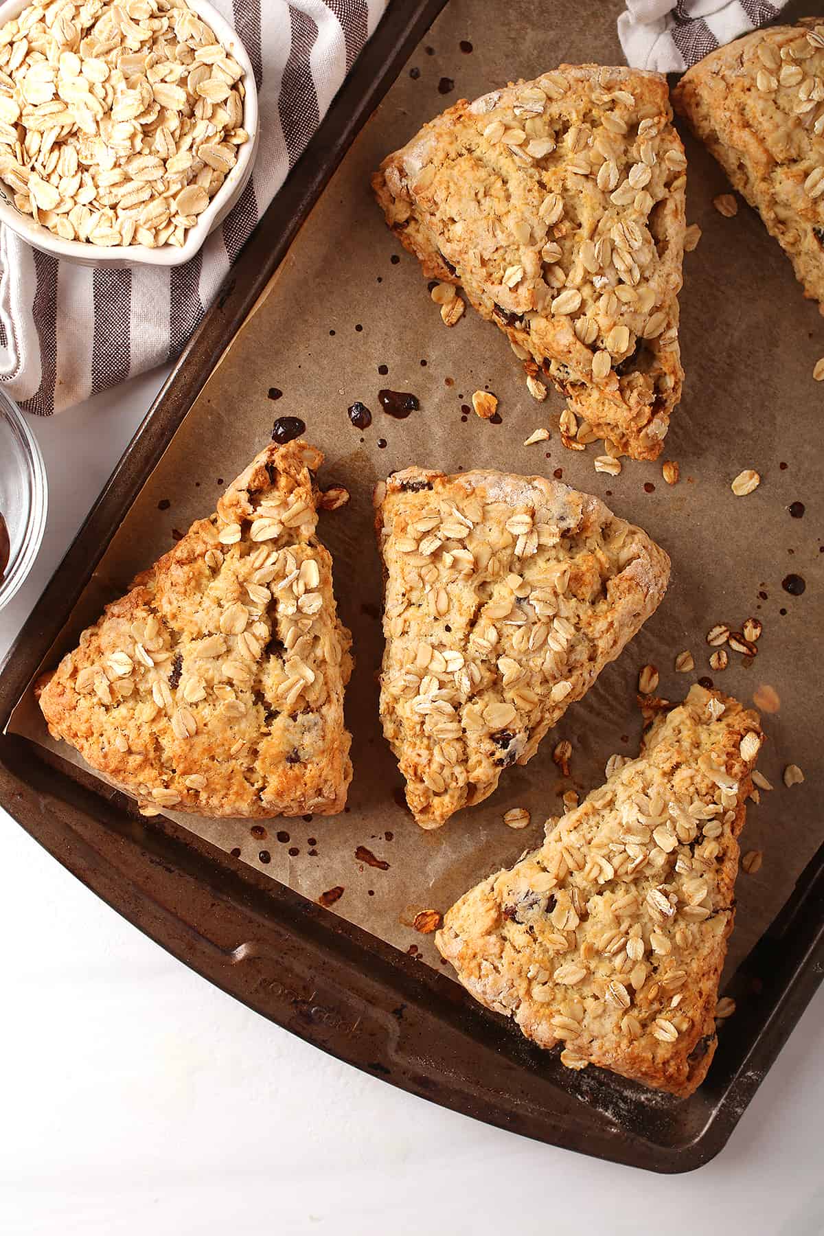 Finished scones on a parchment lined baking sheet placed on a marble countertop. 