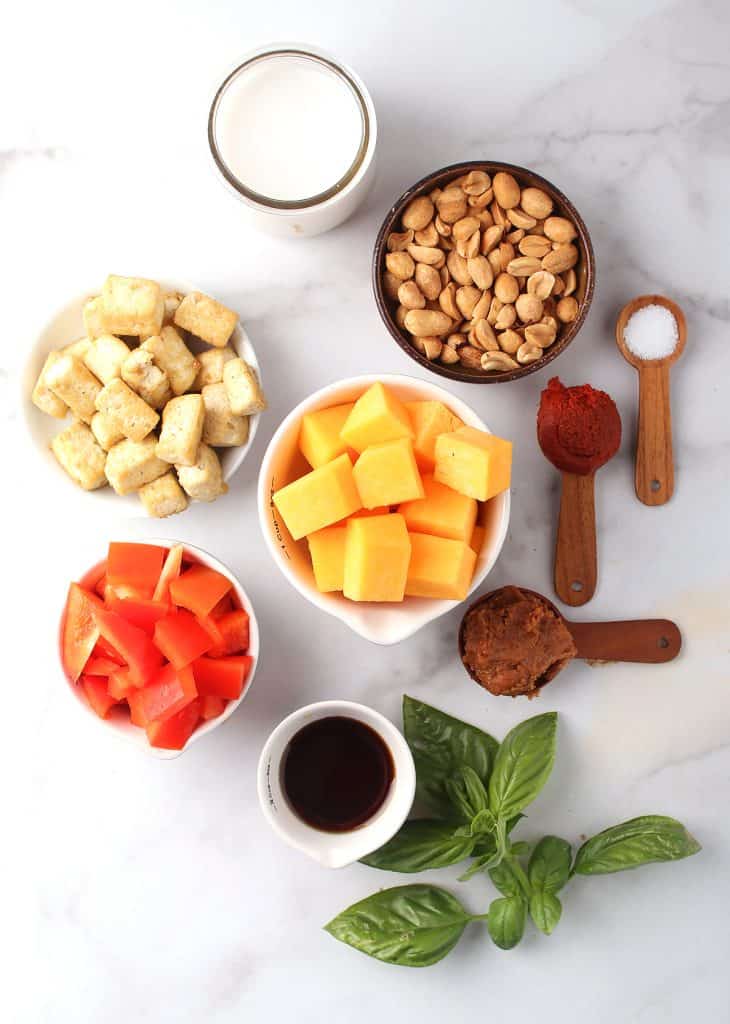 Ingredients for vegan pumpkin curry on a marble countertop