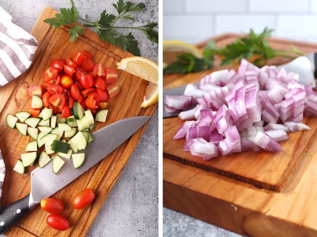 Chopped tomatoes, cucumbers, and onions on a wooden cutting board