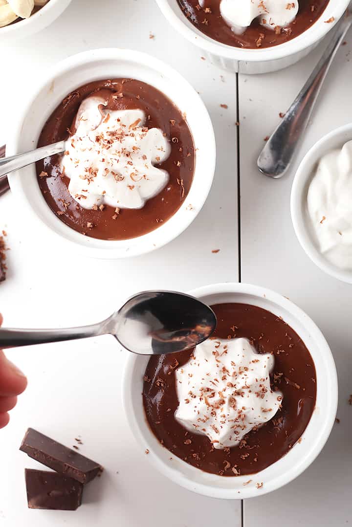 Chocolate custard in white ramekins with whipped cream