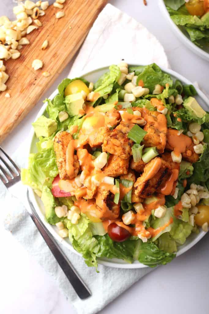 Ensalada terminada en un plato blanco con un tenedor