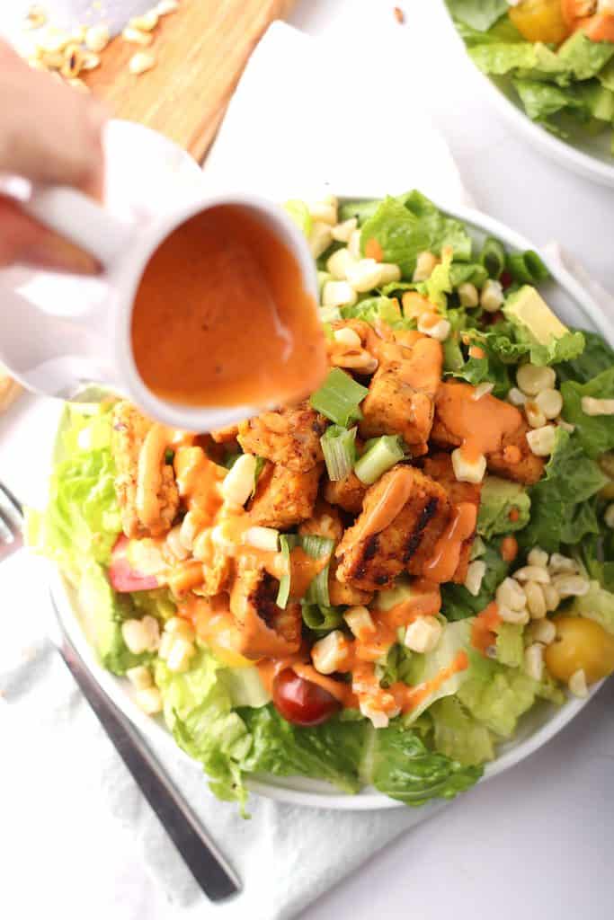 Chipotle ranch dressing pour onto a salad