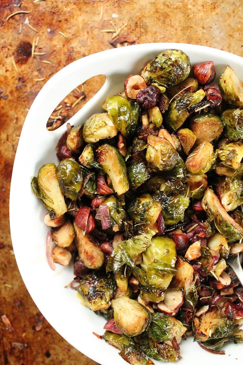 Maple Balsamic Brussels Sprouts with hazelnuts in a white bowl.