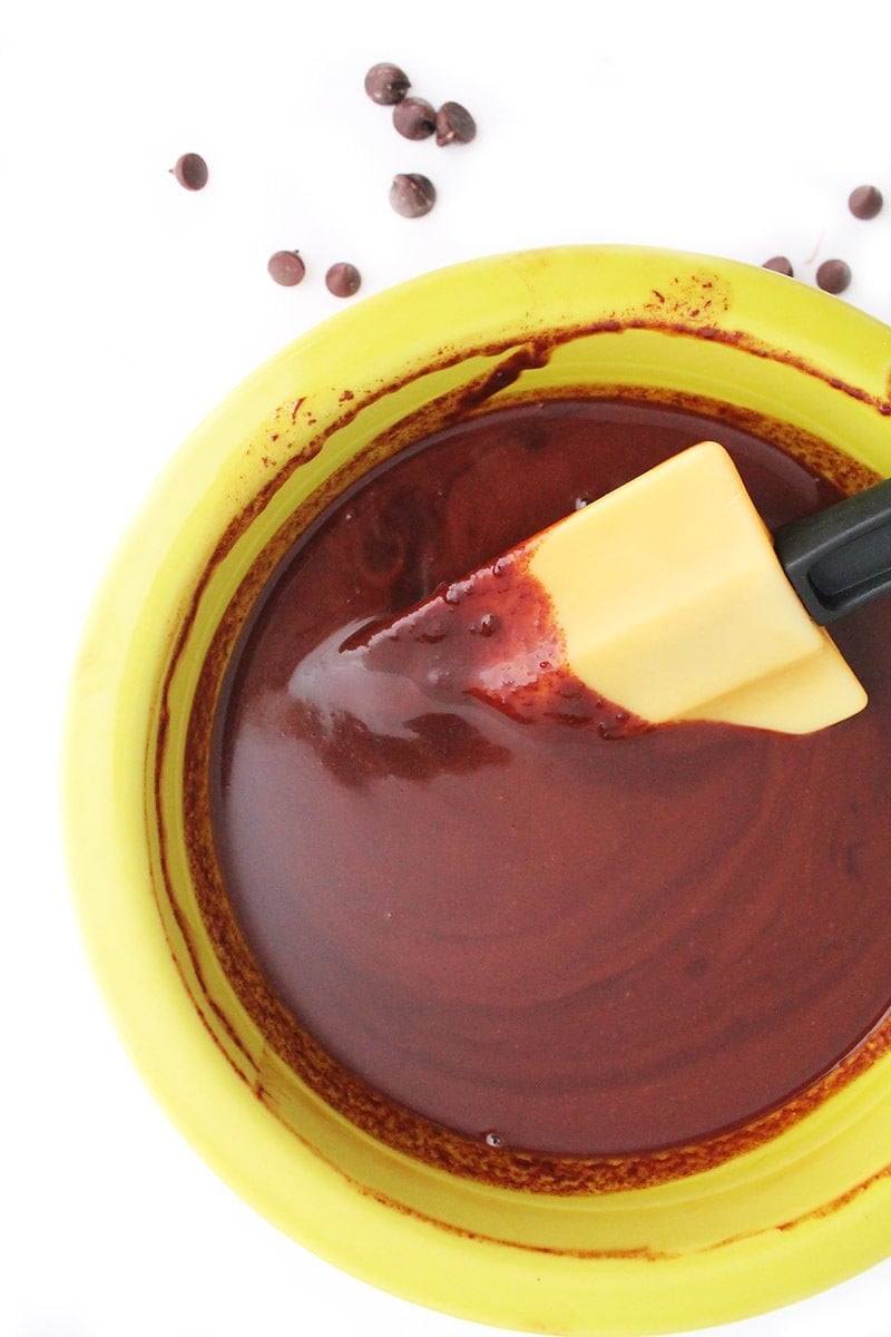 Overhead shot of chocolate ganache in a yellow bowl.