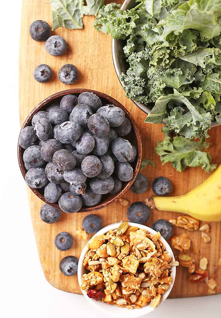 Blueberries and kale on cutting board