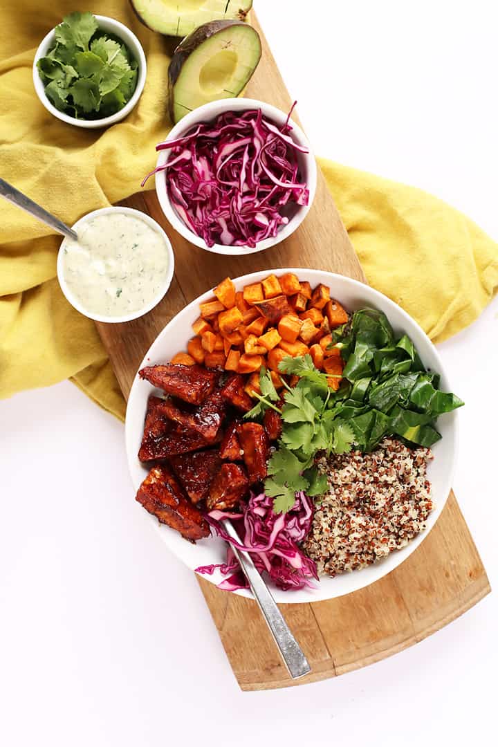 BBQ Tempeh Bowls on a wooden platter with extra toppings