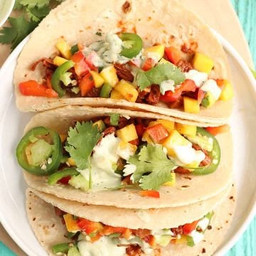 Three vegan tacos on a white plate