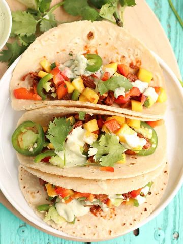 Three vegan tacos on a white plate