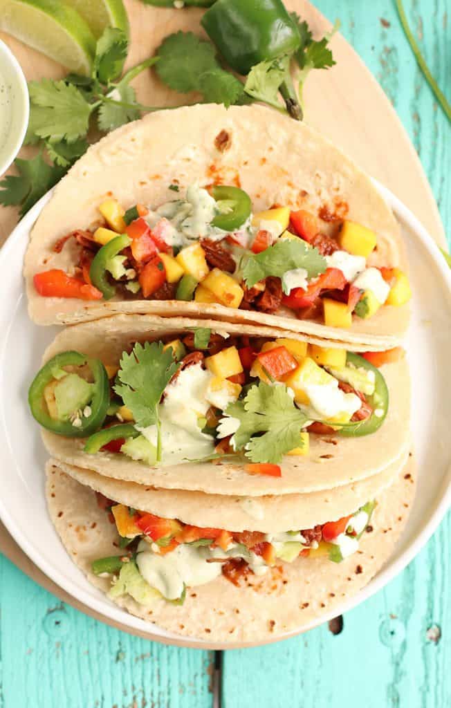 Three vegan tacos on a white plate