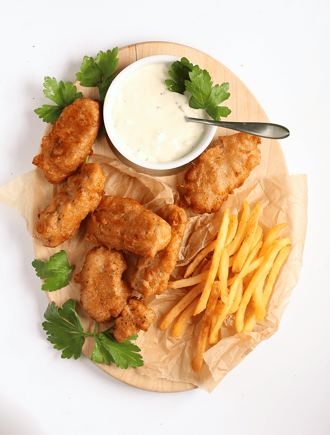 Finished recipe on a wooden platter with fries and tartar sauce