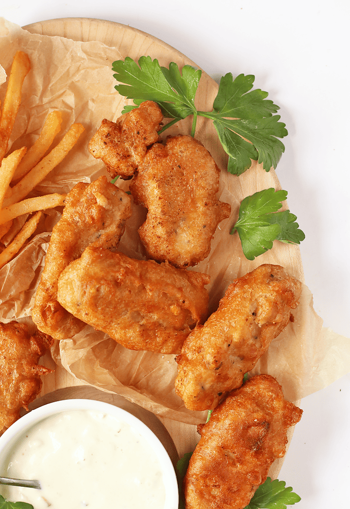 Finished Vegan Fish Sticks on a wooden platter with fries