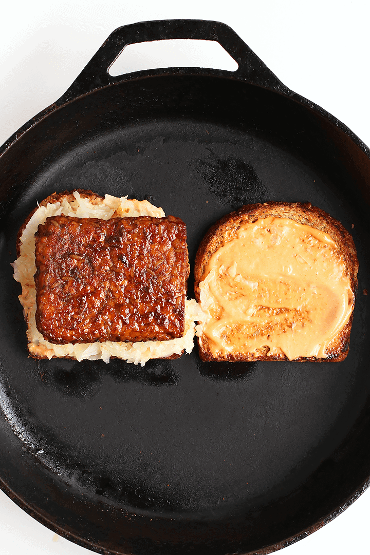 Open faced Tempeh Reuben on a cast iron skillet