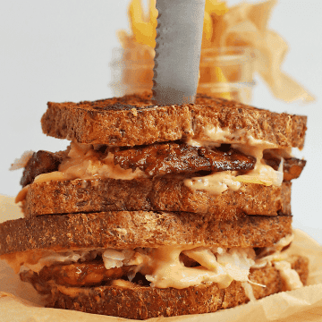 Finished sandwich on a wooden board with a steak knife