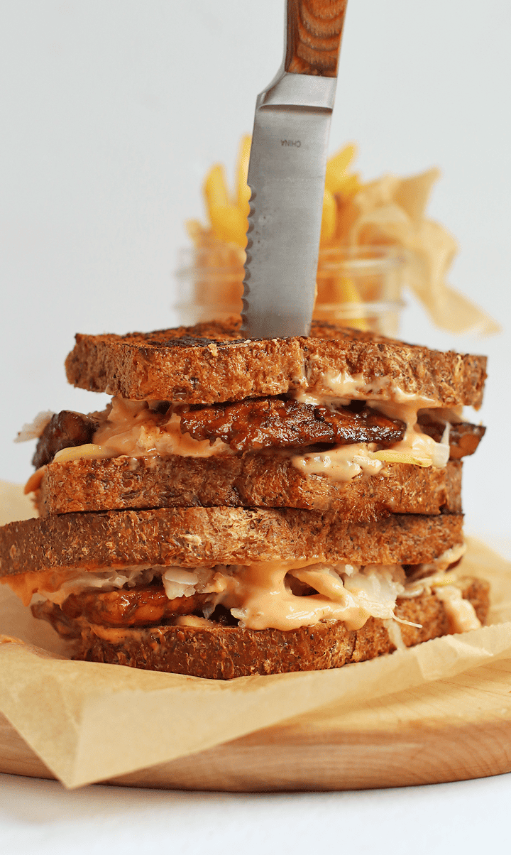 Finished sandwich on a wooden board with a steak knife