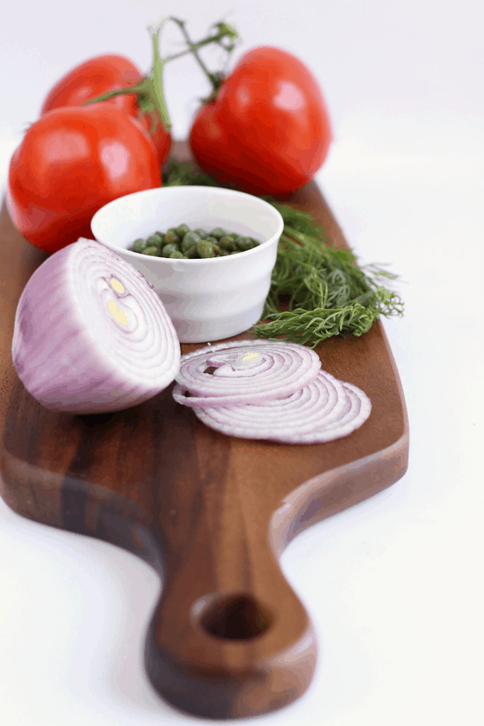 Onions, tomatoes, and herbs on cutting board