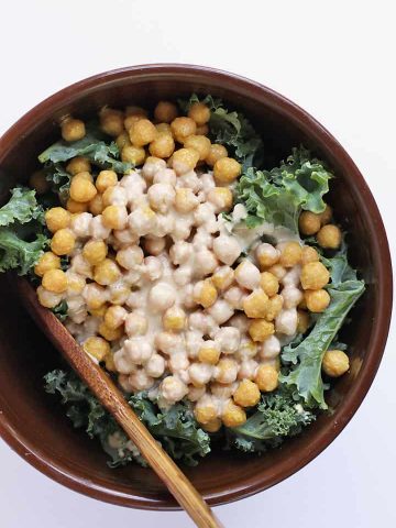 Finished salad in a large salad bowl with a wooden spoon