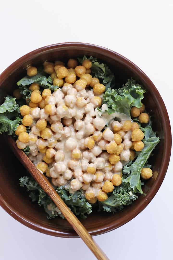 Finished salad in a large salad bowl with a wooden spoon