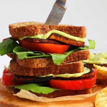 Finished sandwich on a wooden platter with a steak knife