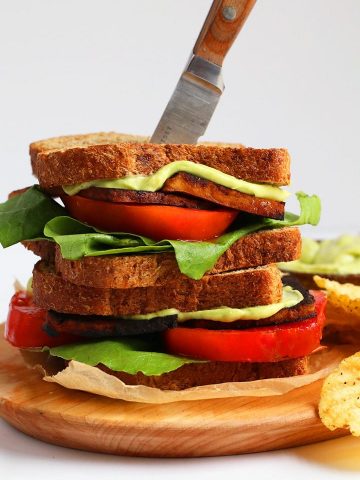 Finished sandwich on a wooden platter with a steak knife