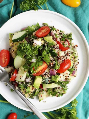 Mediterranean Quinoa Salad on a white plate with a fork