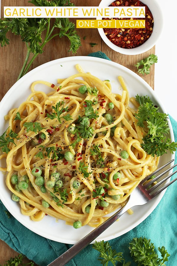 Make dinner easy with this delicious 30 minute one pot vegan Garlic White Wine Pasta topped with fresh parsley, peas, and red pepper flakes. #vegan #vegetarian #pasta #easyrecipes #easydinner #weeknightmeals #mydarlingvegan