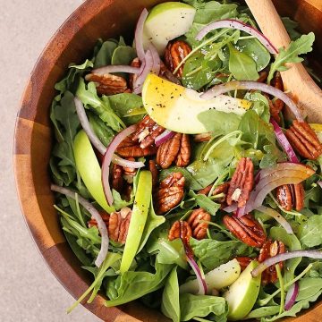 Curry Apple Salad in a salad bowl with wooden spoons