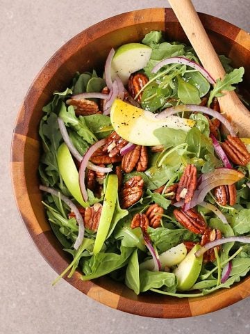 Curry Apple Salad in a salad bowl with wooden spoons