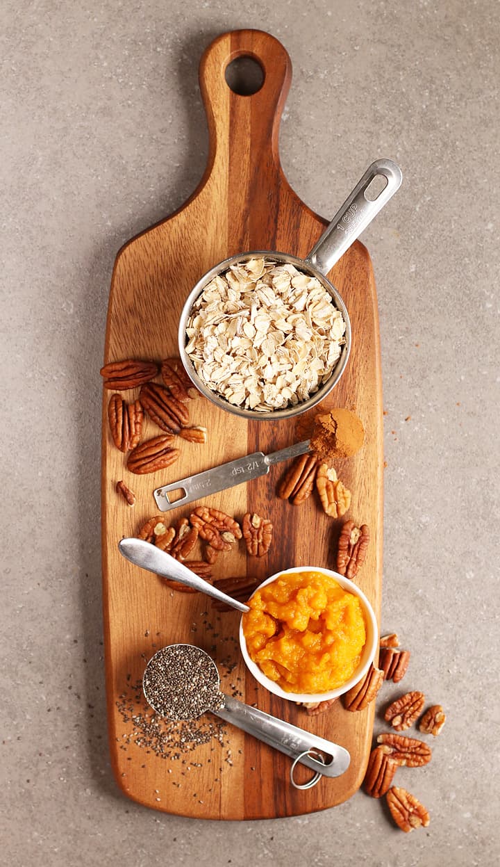 Oats, spices, and pumpkin puree on a cutting board