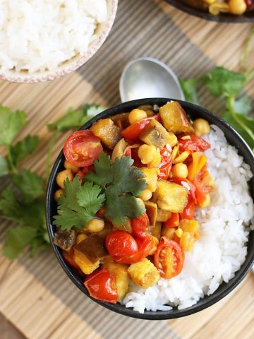 Finished dish served over rice in a small black bowl