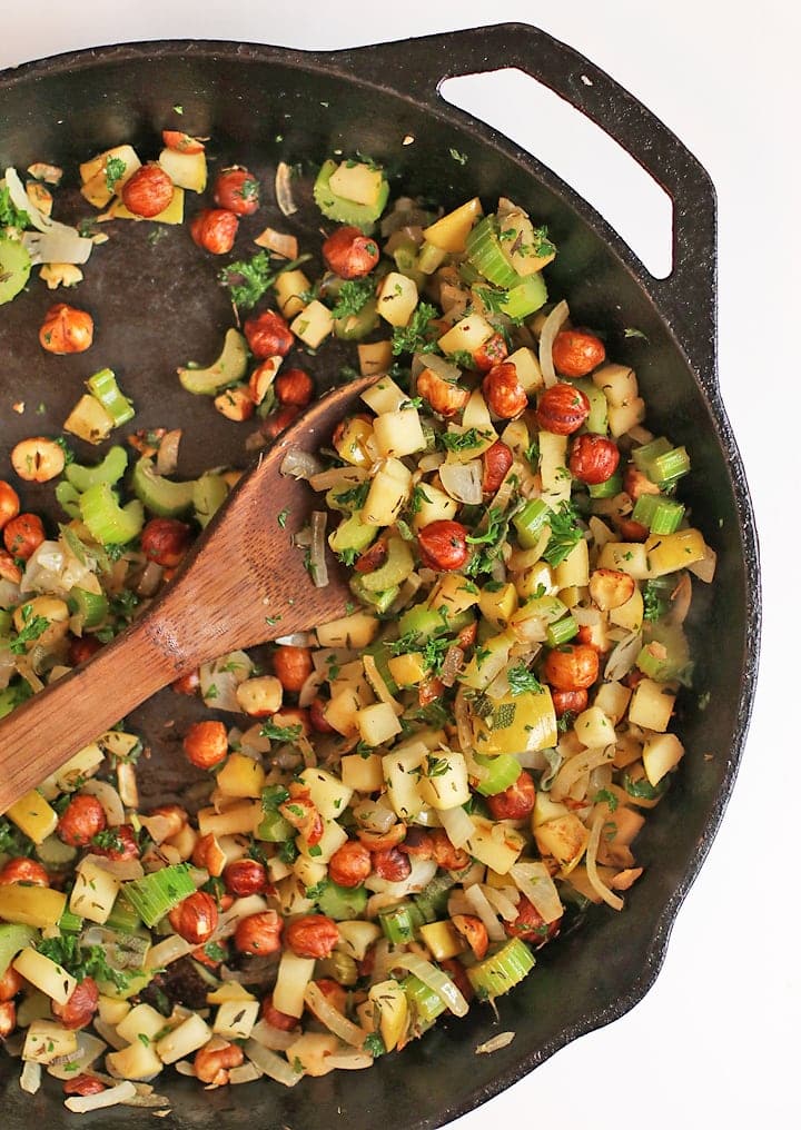 Sautéed onions, celery, and hazelnuts in a cast iron skillet
