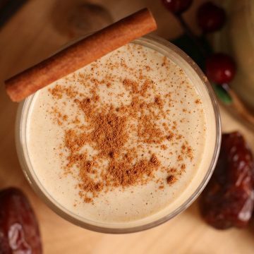 Homemade eggnog in a glass with a cinnamon stick