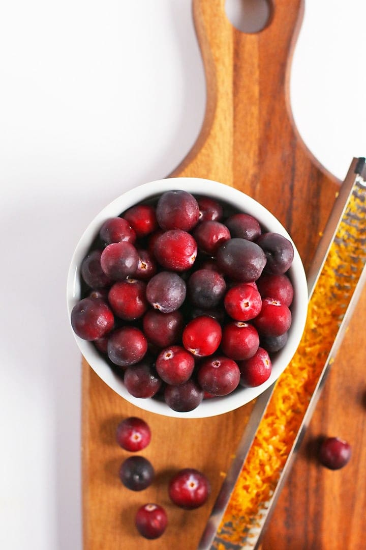 Fresh cranberries and orange zest on a wooden board