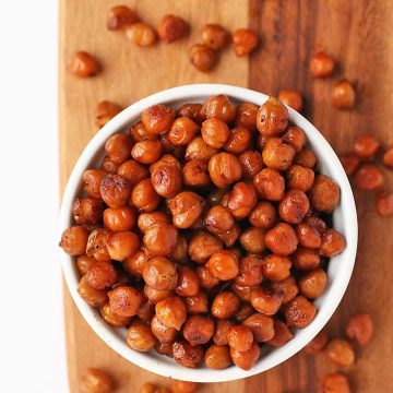 Roasted chickpeas in a white bowl on a wooden background