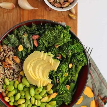 Broccoli, edamame, quinoa, and avocado in a small black bowl