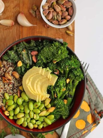 Broccoli, edamame, quinoa, and avocado in a small black bowl