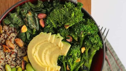 Broccoli, edamame, quinoa, and avocado in a small black bowl