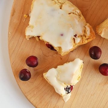 Cranberry Orange Scones broken in half next to fresh cranberries