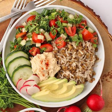 Finished dish in a white bowl on a wooden platter