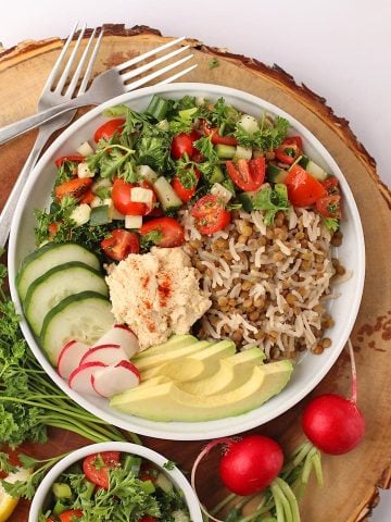 Finished dish in a white bowl on a wooden platter