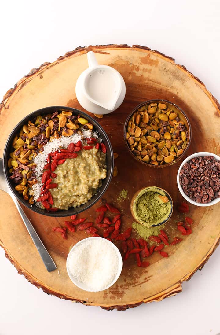 Finished recipe on a wooden platter with cacao nibs, pistachios, and matcha powder