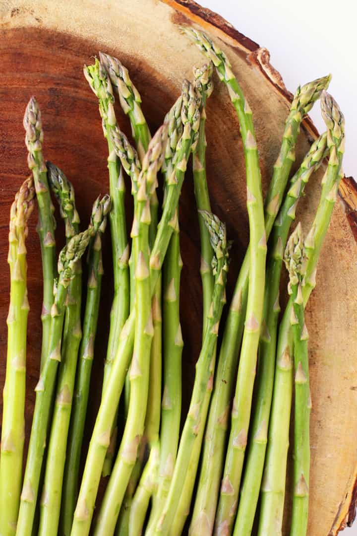 Fresh Asparagus stalks on a wooden platter