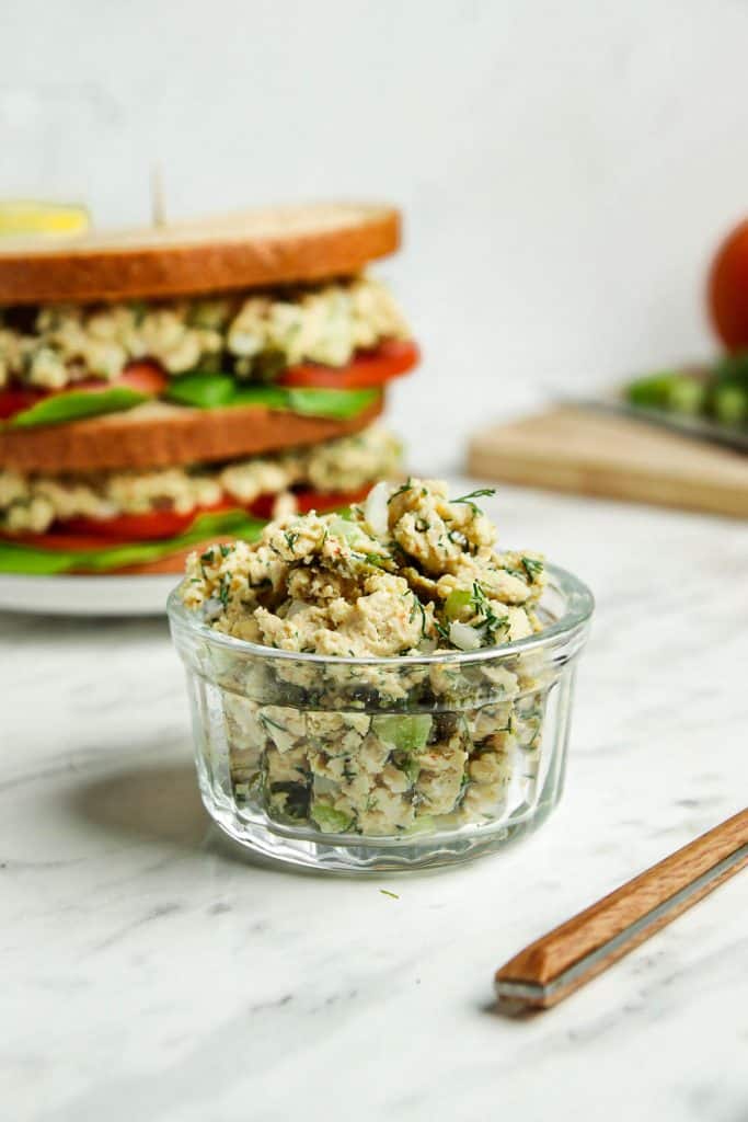 Tuna tempeh salad in a glass serving dish with a finished salad in the background