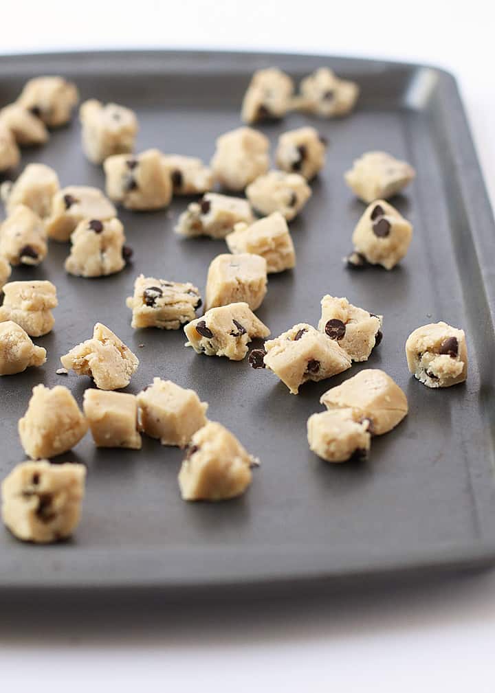 Cookie dough bites spread out on a sheet pan